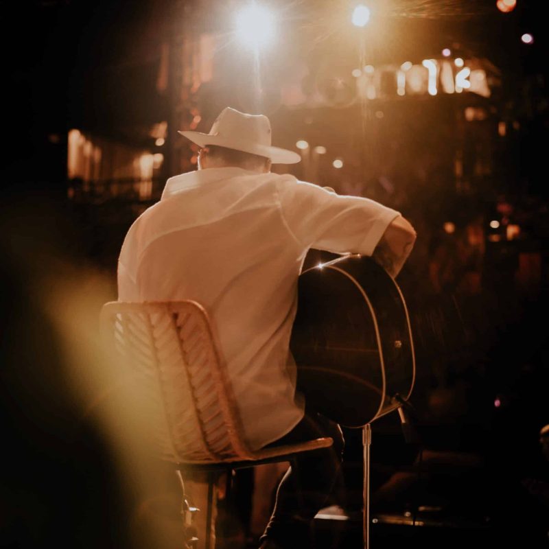 Manuel Moore tocando la guitarra solo con buena luz.